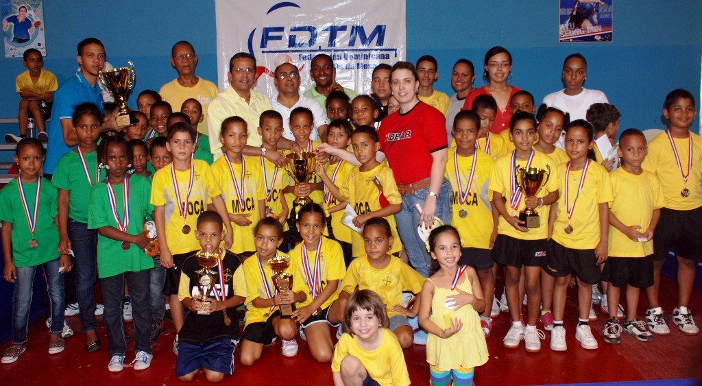 El presidente de la Federación Dominicana de Tenis de Mesa, licenciado Juan Vila, junto a directivos de esa entidad y de otras asociaciones de ese deporte premian a los ganadores generales del evento, en el centro, atletas y dirigentes de Moca; en la izquierda, los de San Pedro de Macorís y en la derecha, los de Santiago.